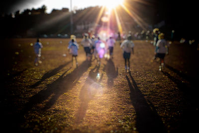 Group of people walking in park during sunset