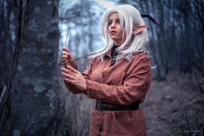 Woman wearing mask standing in forest