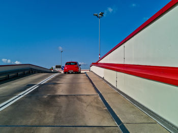 Vehicles on road against blue sky