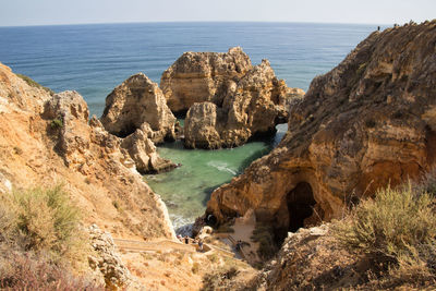 Scenic view of rocks in sea against sky