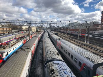 High angle view of trains in city against cloudy sky