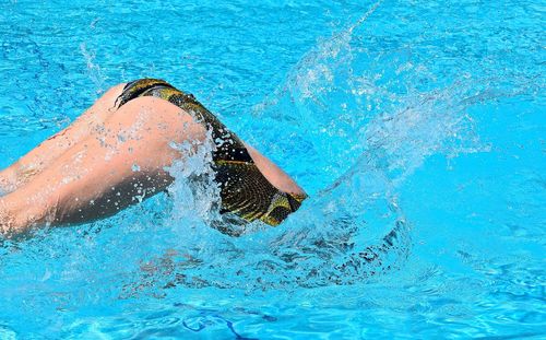 Midsection of woman swimming in pool