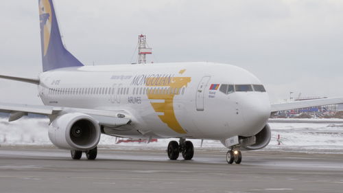 Airplane on airport runway against sky