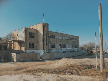 Old building on field against blue sky