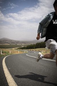 Rear view of man on road against sky