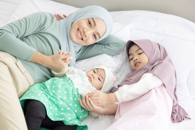 Baby and mother at home in bed, happy loving family