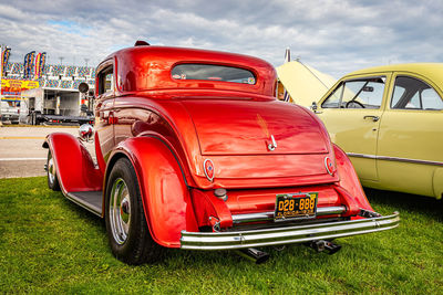 Red vintage car in city against sky