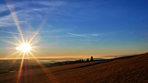 Scenic view of vapor trails in sky during sunset