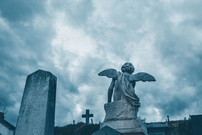 Low angle view of angel statue against sky