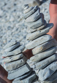 Cropped woman stacking rocks at beach