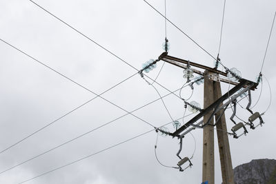 Low angle view of electricity pylon against sky