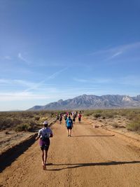 Rear view of people running at desert during marathon