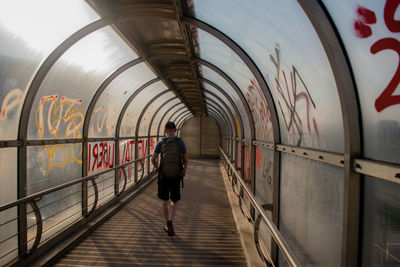 Rear view of man walking on railway station
