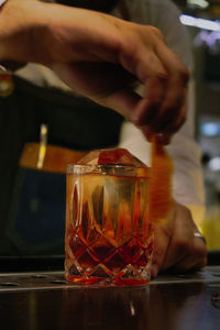 Midsection of man with drink on table in restaurant