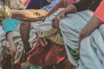 Midsection of people holding fabric