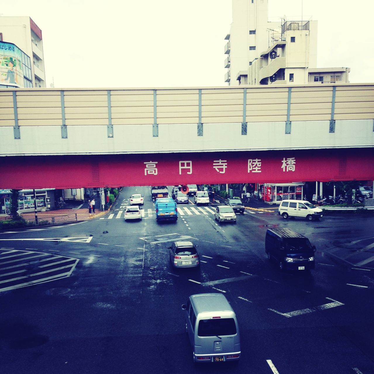 transportation, mode of transport, car, land vehicle, architecture, built structure, building exterior, street, city, road, traffic, travel, public transportation, clear sky, road marking, text, city life, on the move, incidental people, city street