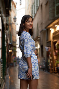 Portrait of young woman standing in city