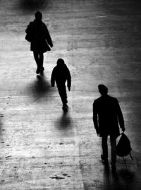 Rear view of silhouette people walking on floor
