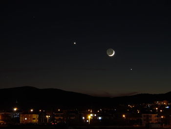 View of illuminated city against clear sky at night