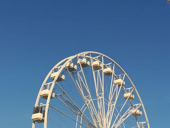 Low angle view of ferris wheel against clear blue sky