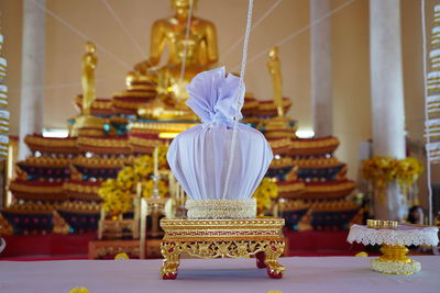 Close-up of lit candles on table in temple