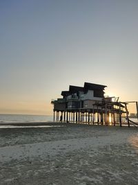 Scenic view of beach against clear sky during sunset