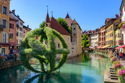 Canal amidst buildings in town against sky