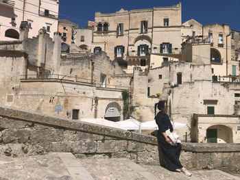 Man standing by old building in city