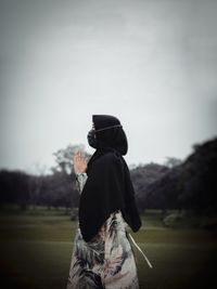 Man with dog on field against sky