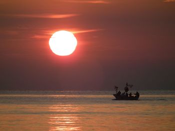 Boat sailing in sea at sunset