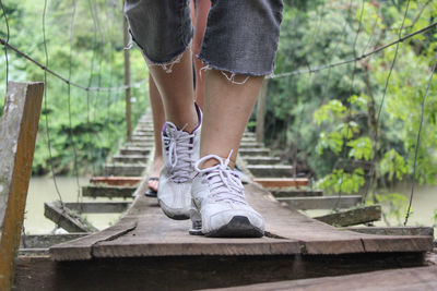 Low section of men walking on footbridge over river