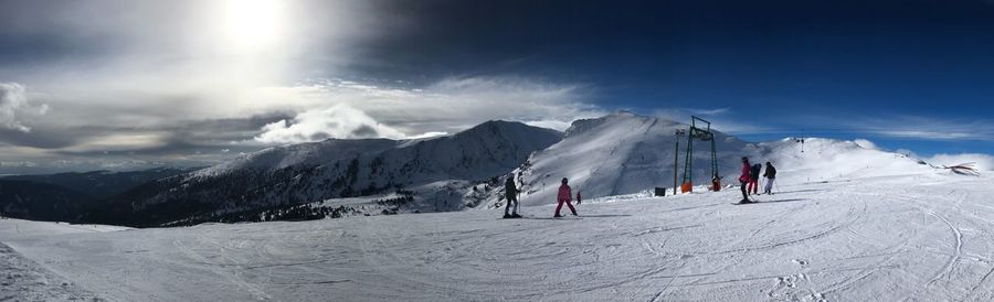 Panoramic view of people skiing on snowcapped mountain