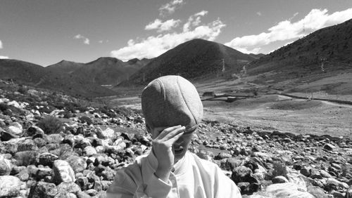Man wearing flat cap against mountains