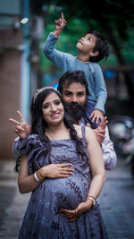 Portrait of smiling mother and father with their son on father's shoulder 