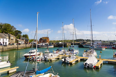 Sailboats moored in harbor