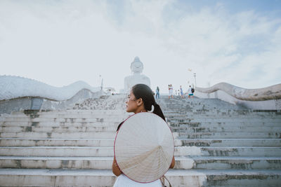 Rear view of woman standing against sky during winter