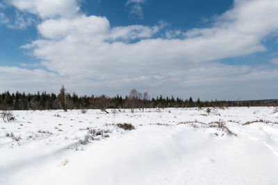 Scenic view of snow covered land against sky