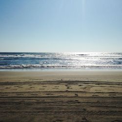 Scenic view of beach against clear blue sky