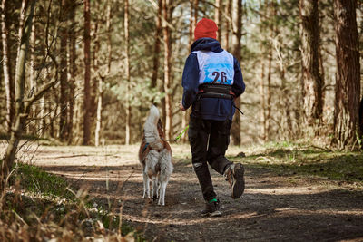 Rear view of man walking in forest