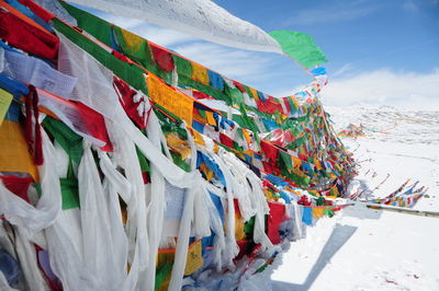 Multi colored flags hanging outside temple against sky