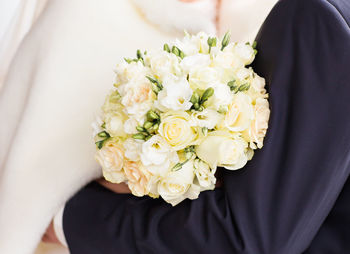 Close-up of woman holding bouquet of white rose