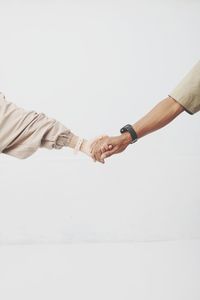 Cropped hand of man gesturing against white background