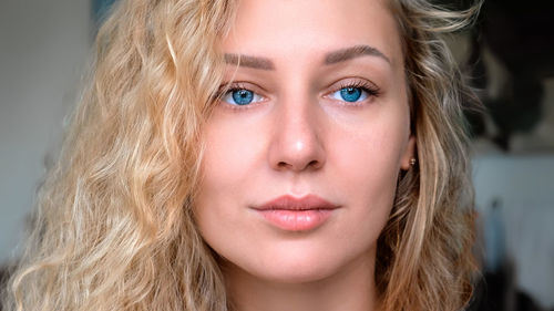 Portrait of an attractive charming smiling young woman with curly white hair and blue eyes