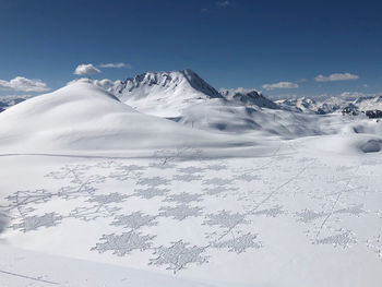 Scenic view of snow covered mountains against sky