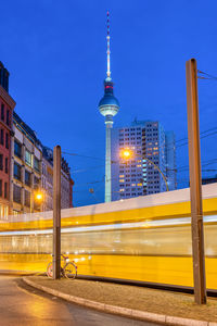 The famous tv tower in berlin at night with a moving tramway