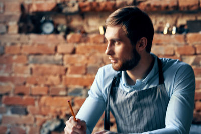 Young man looking at camera against wall