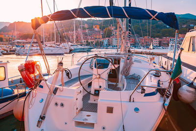 Sailboats moored at harbor against sky