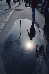 Low section of people walking on road in city