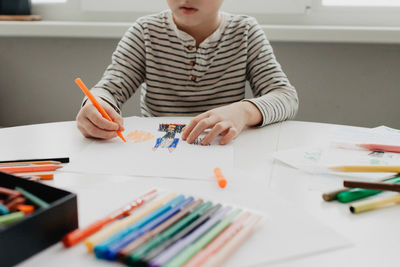 The boy draws with felt-tip pens. high quality photo