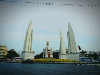 Statue in city against sky